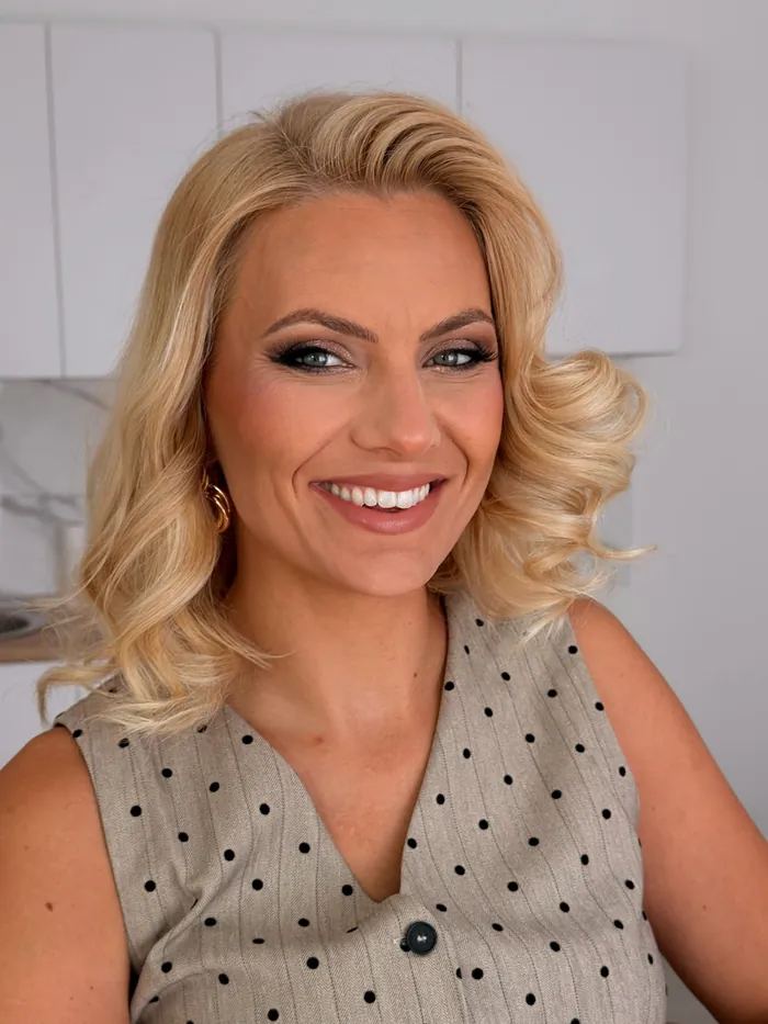 Nasmejana plavuša sa loknama i glam šminkom